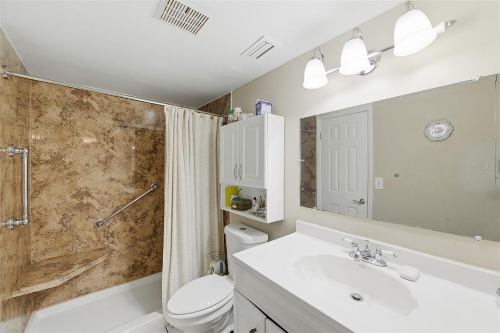 7701 Starkey Road, Unit 237 Seminole, FL 33777 - Photo 21 of 32 a bathroom with a sink a toilet a mirror a vanity and shower