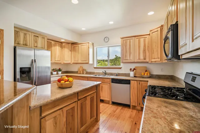 a kitchen with stainless steel appliances a sink a stove a refrigerator and cabinets