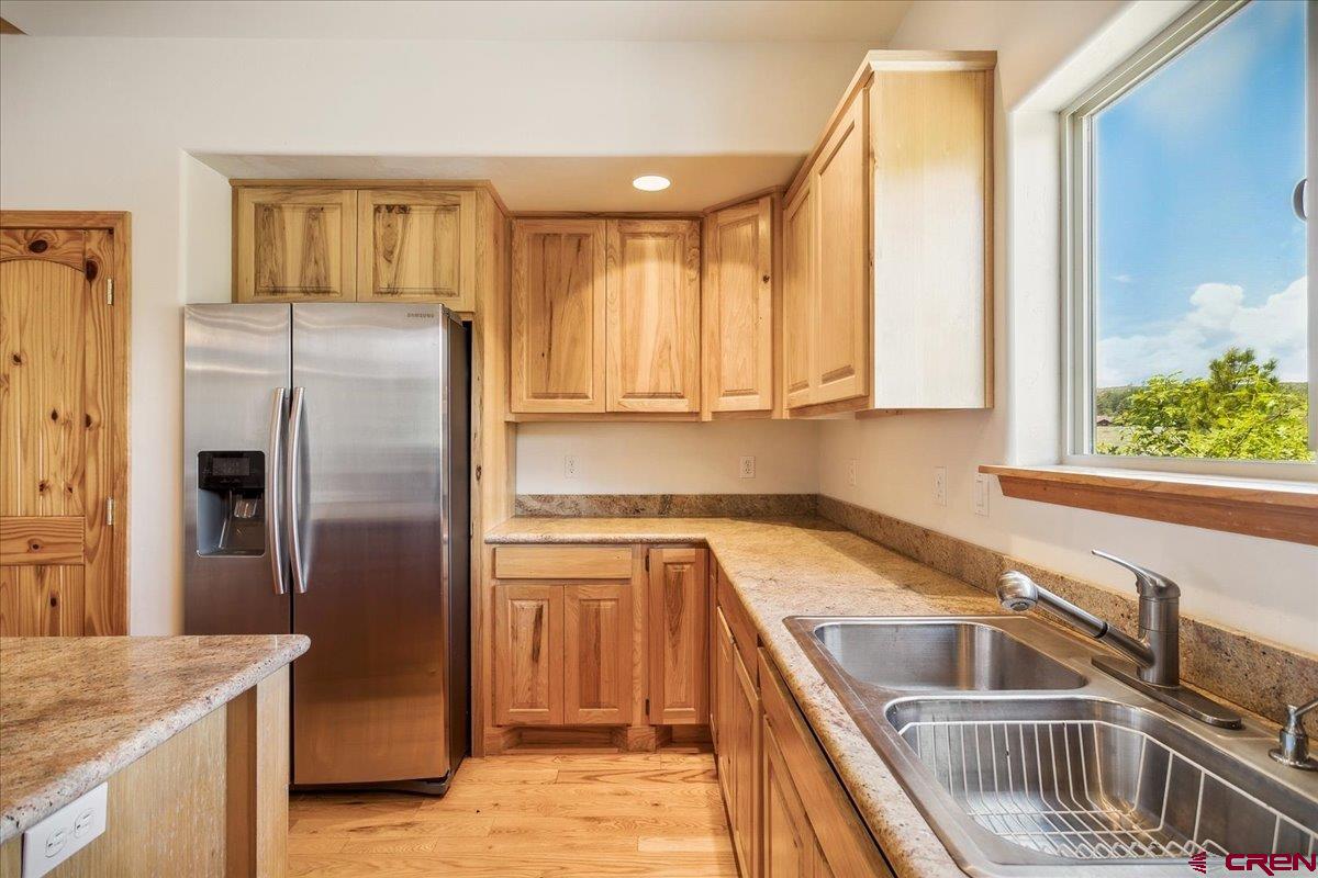196 Dylan Drive Pagosa Springs, CO 81147 - Photo 27 of 44 a kitchen with stainless steel appliances granite countertop a refrigerator a sink and dishwasher