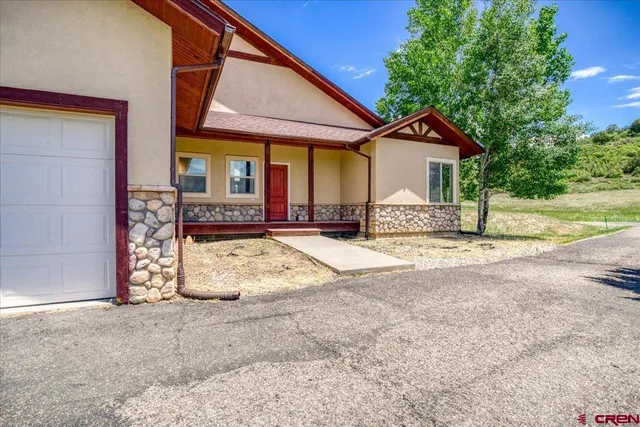 a view of a house with a patio and a yard