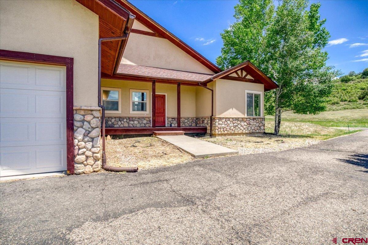 196 Dylan Drive Pagosa Springs, CO 81147 - Photo 10 of 44 a view of a house with a patio and a yard