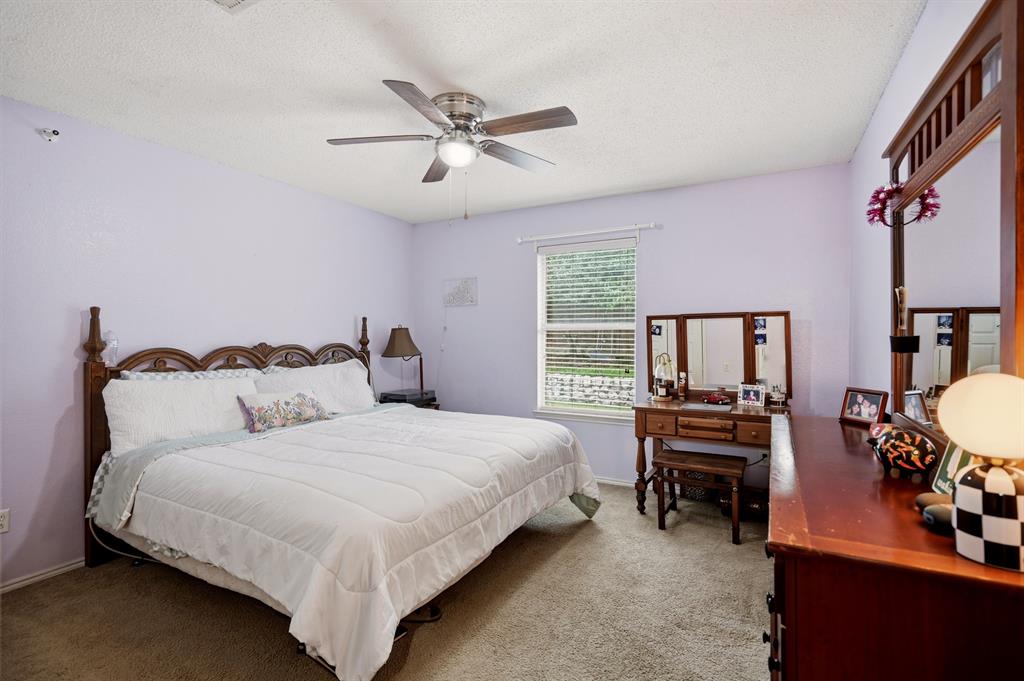 1213 Hampton Drive Forney, TX 75126 - Photo 6 of 27 a bedroom with bed and a chandelier
