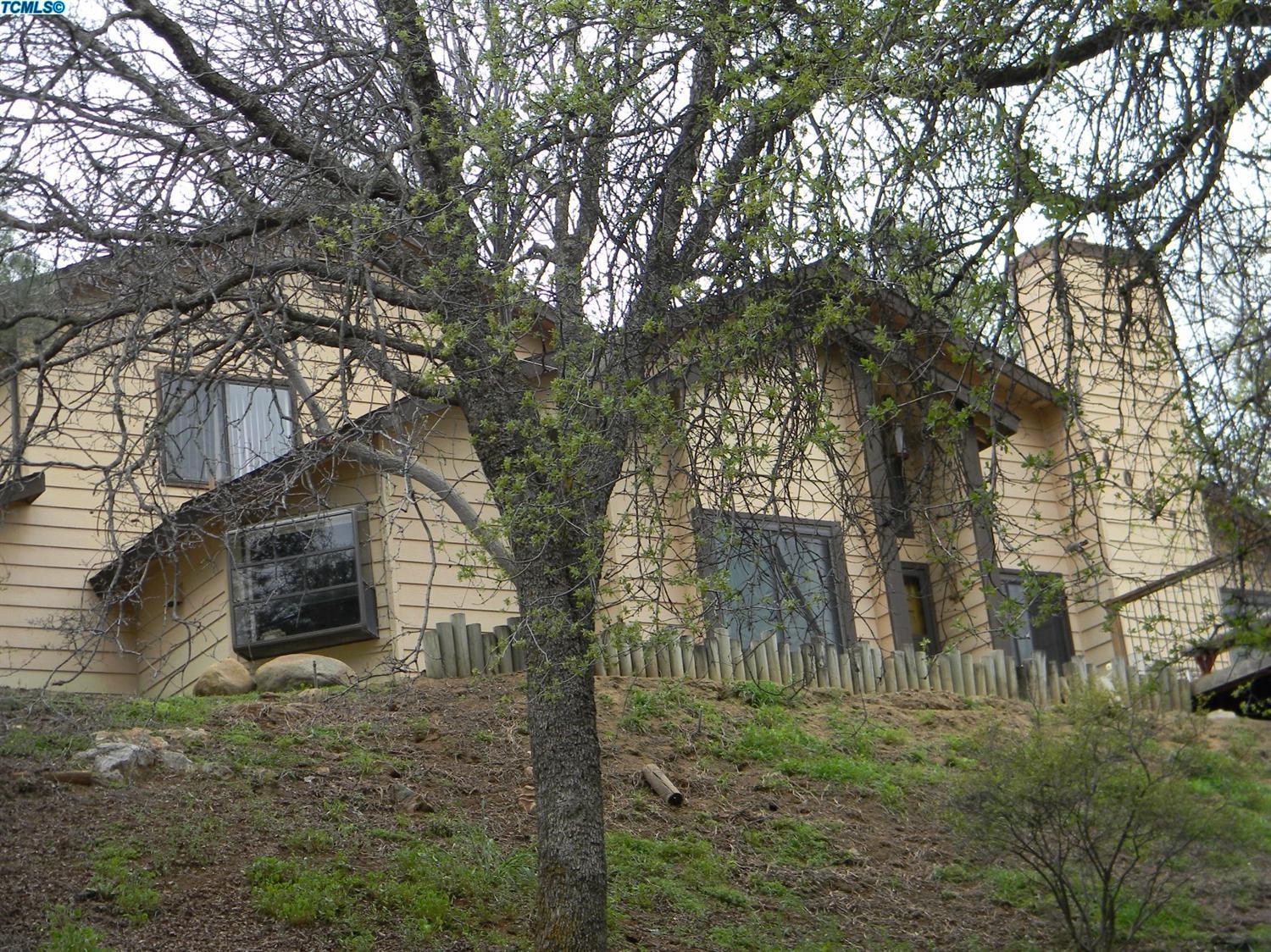 40675 Crystal Drive Three Rivers, CA 93271 - Photo 11 of 34 a yellow house with trees in front of it