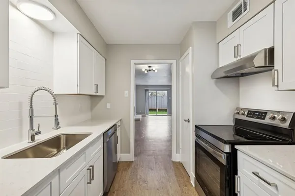 a kitchen with a sink stove and cabinets