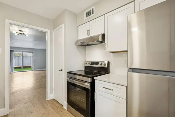 a kitchen with stainless steel appliances a stove a refrigerator and cabinets
