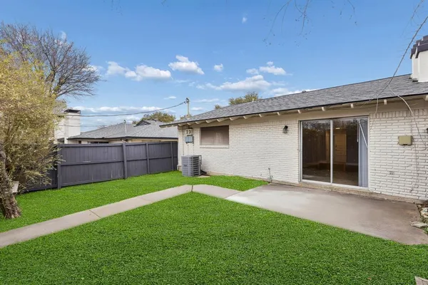 a view of a backyard with potted plants and large tree