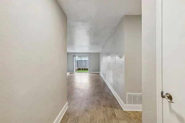 a view of a hallway with wooden floor and staircase