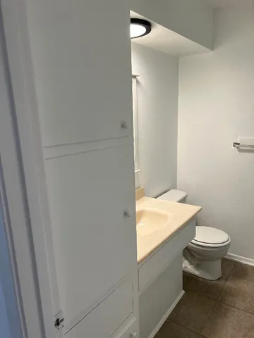 a bathroom with a granite countertop toilet and a sink