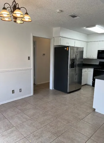 a view of kitchen with refrigerator and cabinets