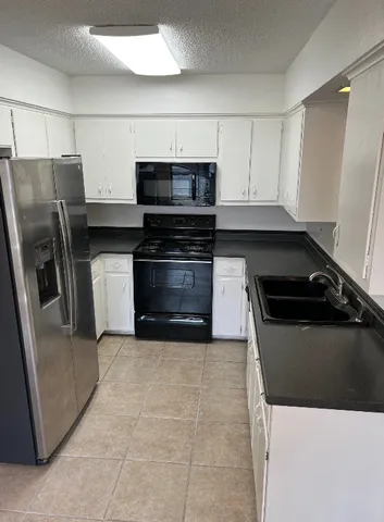 a kitchen with granite countertop a refrigerator and a stove