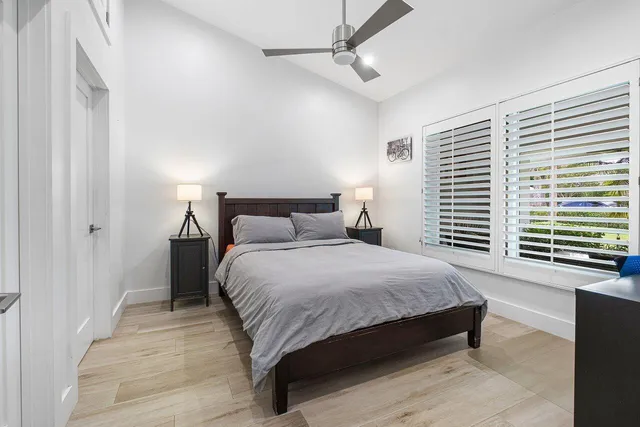 a bedroom with a large bed and a chandelier fan