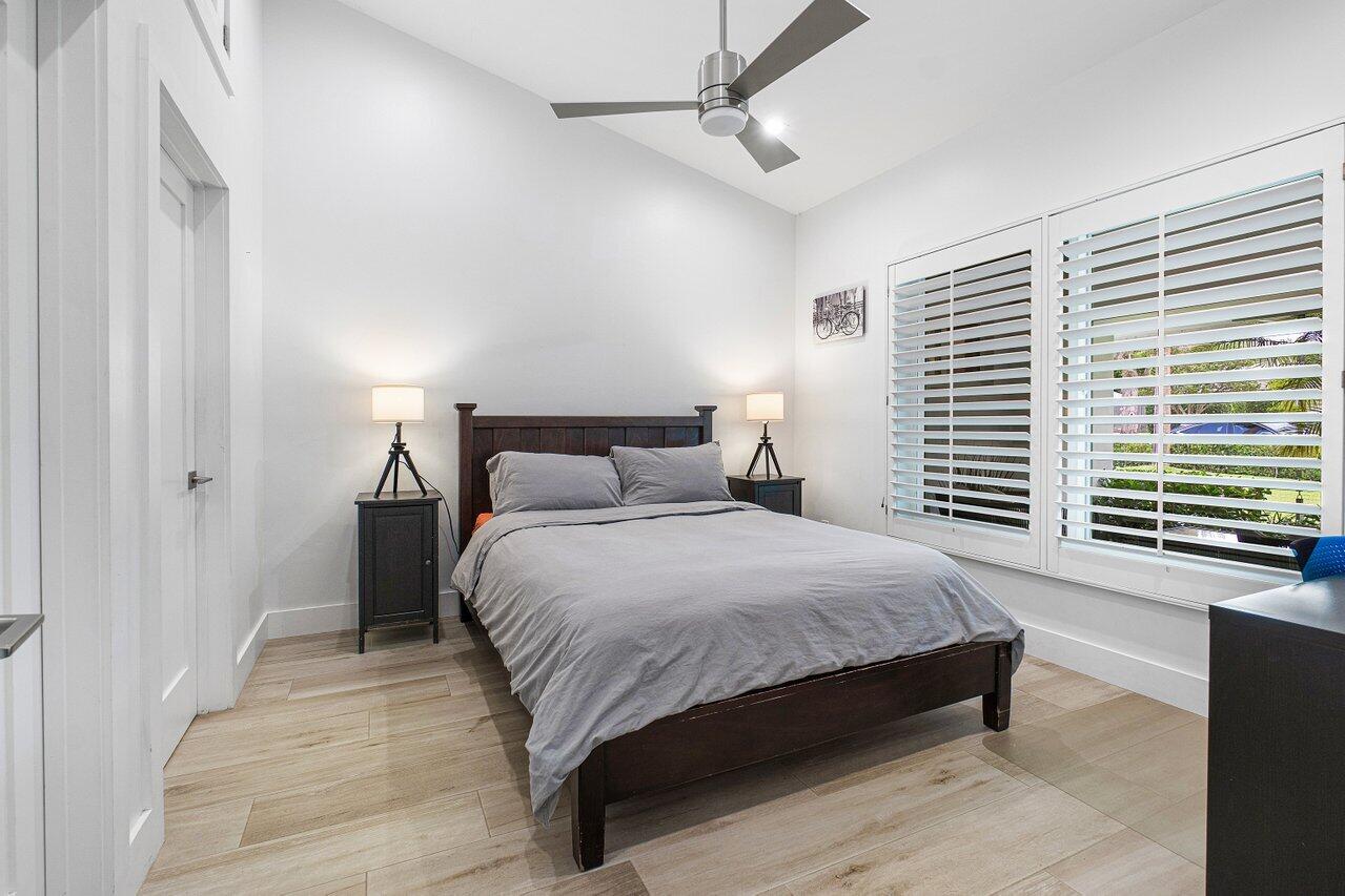 936 Southwest 38th Court Boynton Beach, FL 33435 - Photo 14 of 18 a bedroom with a large bed and a chandelier fan