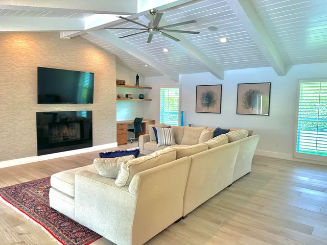 a living room with furniture a flat screen tv and a fireplace