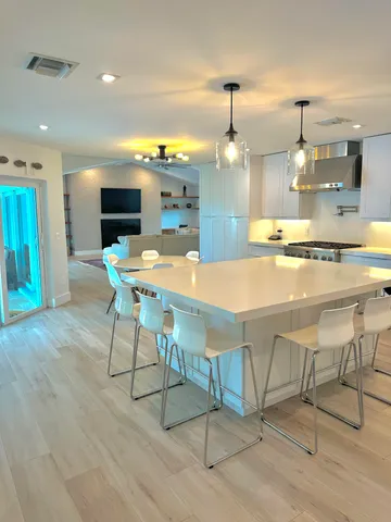 a kitchen with kitchen island stainless steel appliances a table and chairs in it