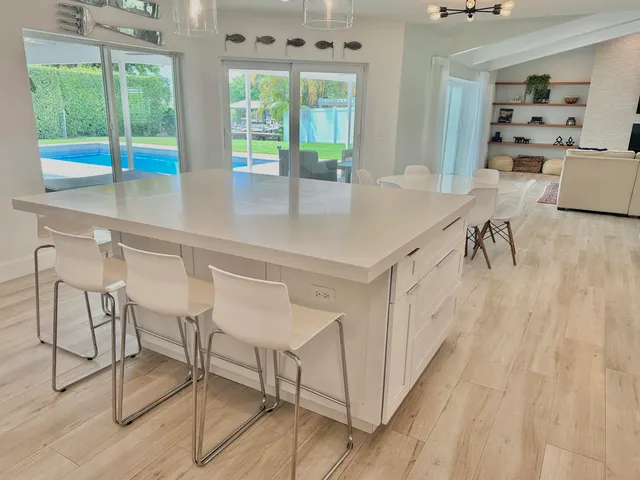 a kitchen with a table chairs and white cabinets