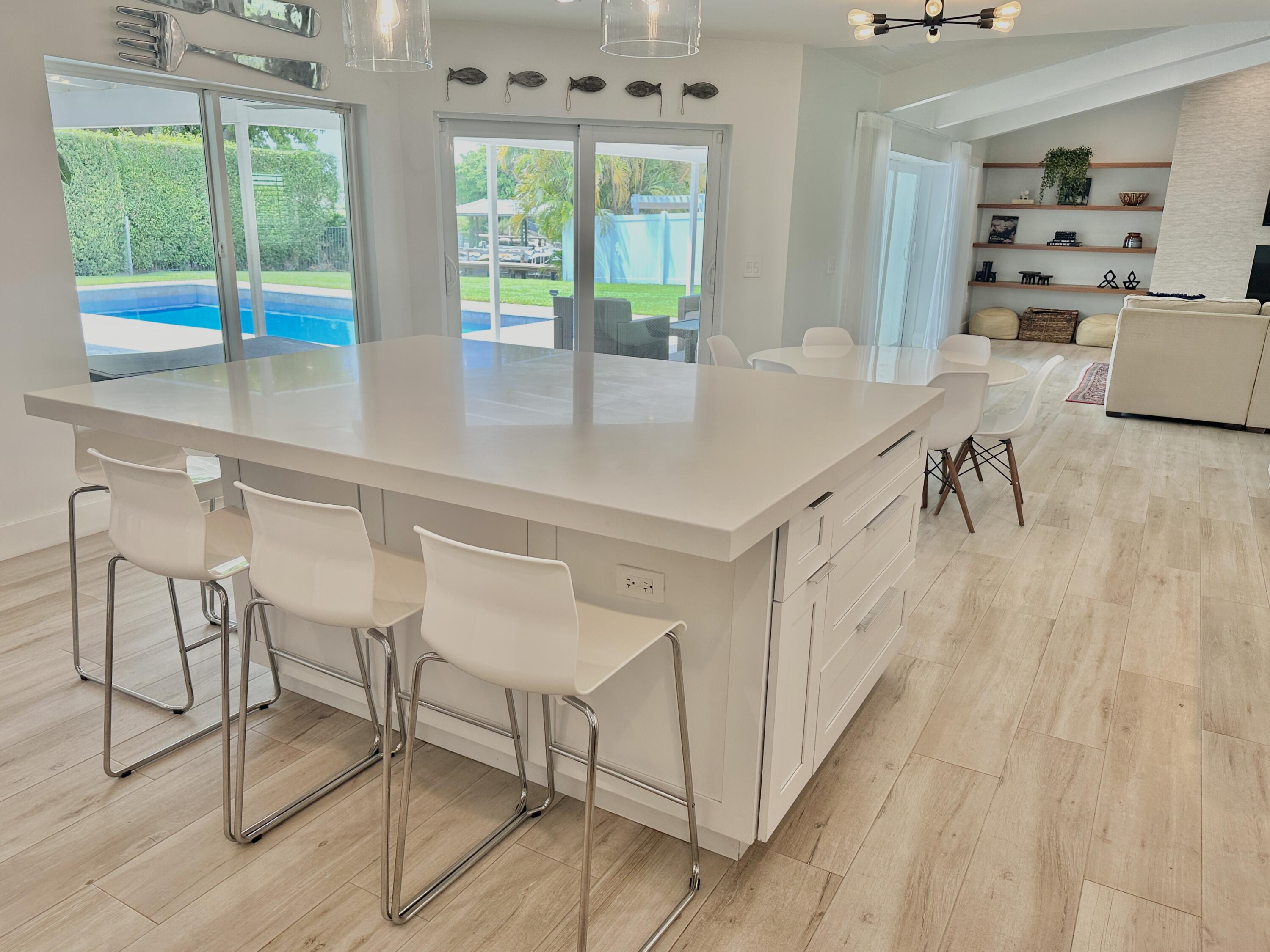 936 Southwest 38th Court Boynton Beach, FL 33435 - Photo 8 of 18 a kitchen with a table chairs and white cabinets