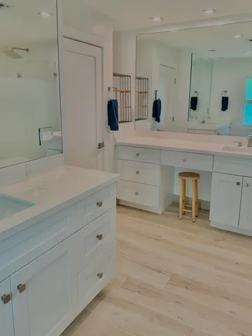 a spacious bathroom with a double vanity sink mirror and bathtub