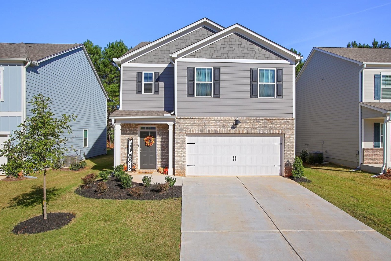 a front view of a house with a yard and garage