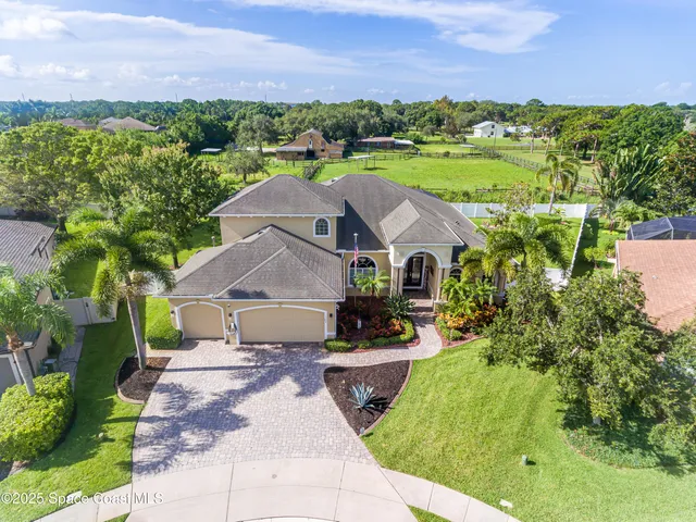 a aerial view of a house with a garden and a yard