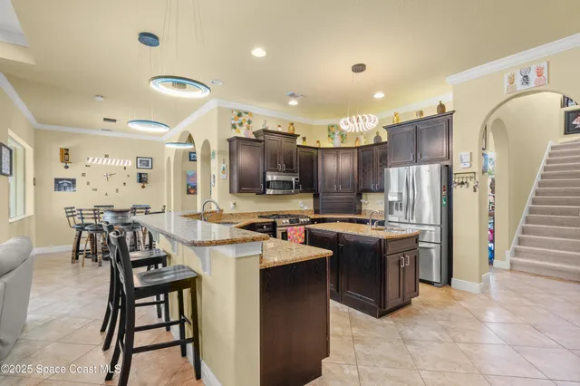 a kitchen with refrigerator and chairs