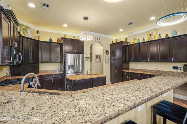 a kitchen with stainless steel appliances granite countertop a sink refrigerator and cabinets