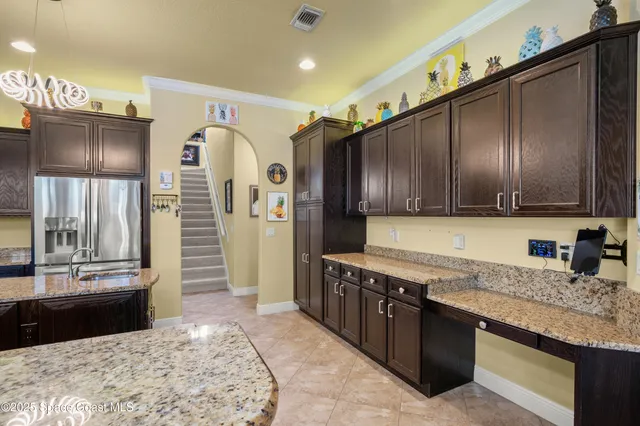 a large kitchen with granite countertop a stove refrigerator and cabinets