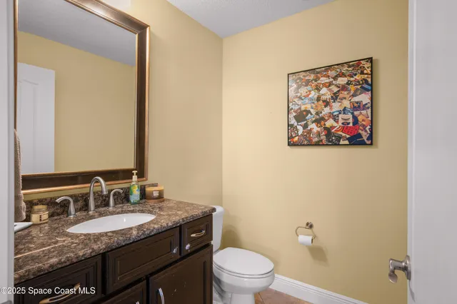 a bathroom with a granite countertop sink toilet and a mirror