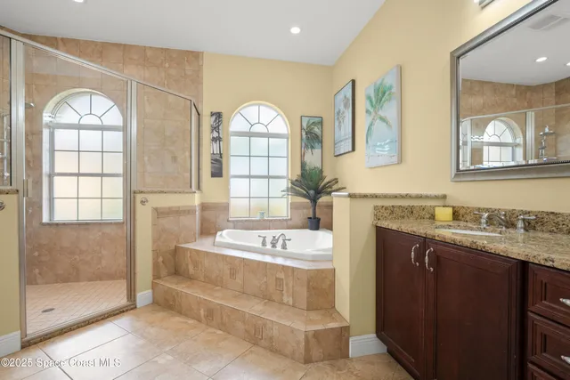 a bathroom with a sink a vanity a mirror and a bathtub