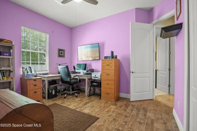 a view of a workspace with furniture and a window