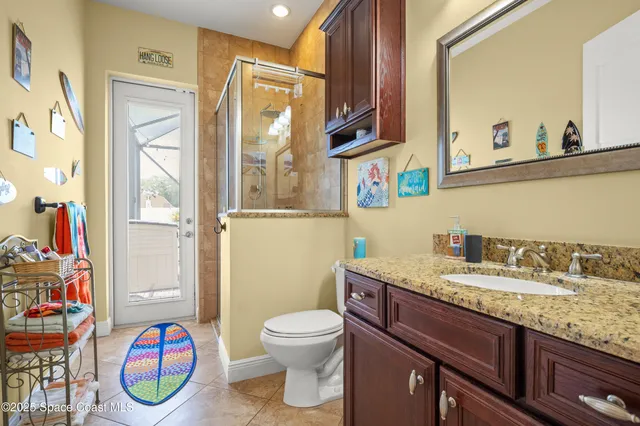a bathroom with a granite countertop toilet sink and mirror