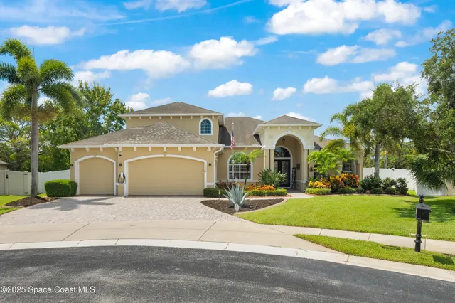 a front view of a house with a garden and yard