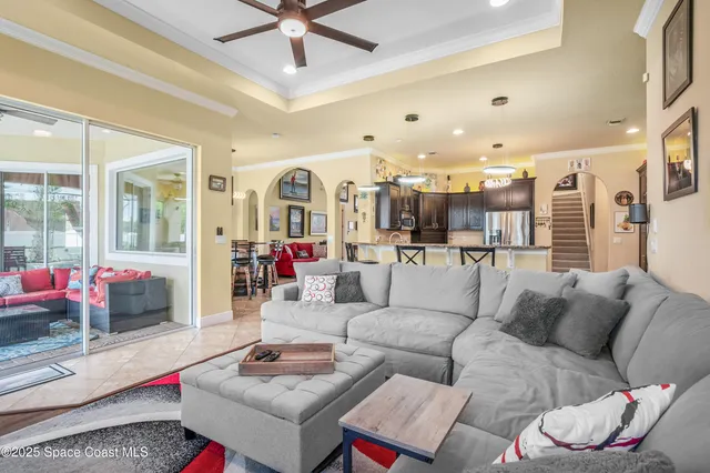 a living room with furniture and a ceiling fan