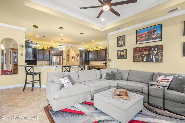 a living room with furniture kitchen view and a chandelier