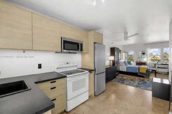 a kitchen that has a lot of cabinets a sink and appliances