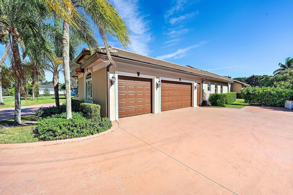 8480 Man O War Road Palm Beach Gardens, FL 33418 - Photo 37 of 45 a backyard of a house with a garden and plants
