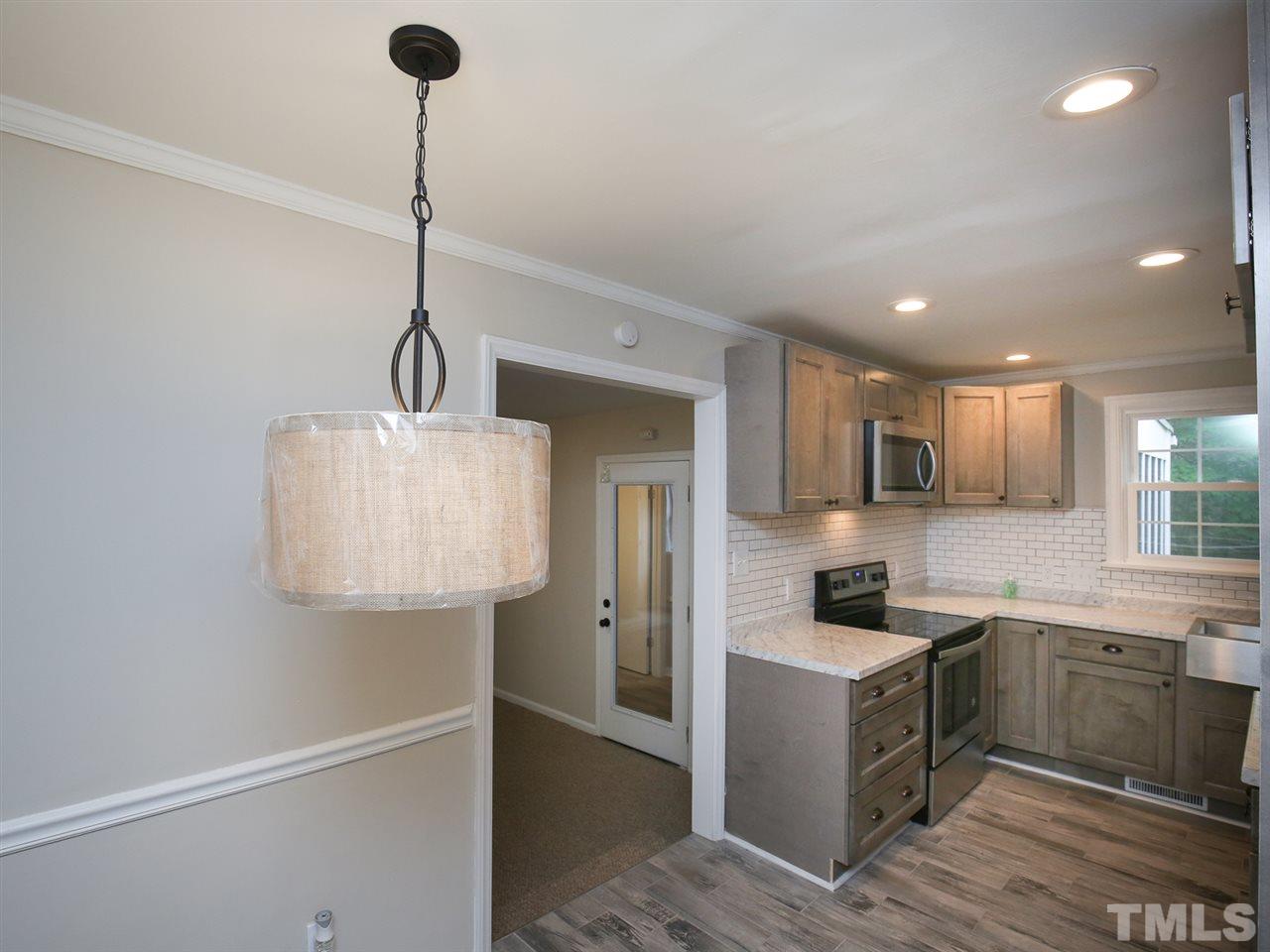 312 Colleton Road Raleigh, NC 27610 - Photo 13 of 25 a kitchen with stainless steel appliances granite countertop a sink a stove and refrigerator