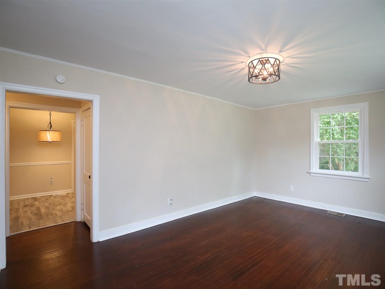 312 Colleton Road Raleigh, NC 27610 - Photo 3 of 25 an empty room with wooden floor and windows