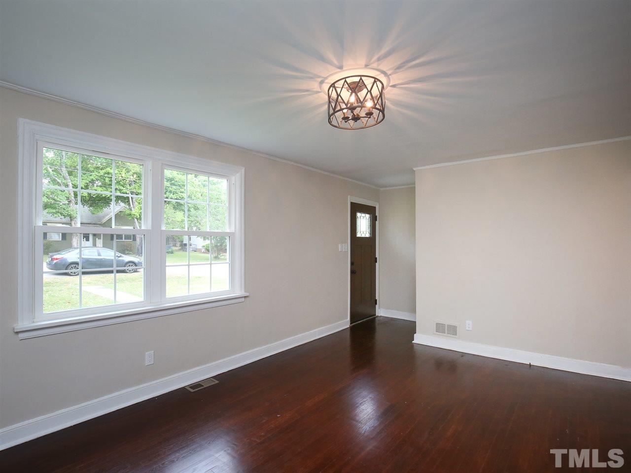 312 Colleton Road Raleigh, NC 27610 - Photo 4 of 25 a view of an empty room with wooden floor and a window