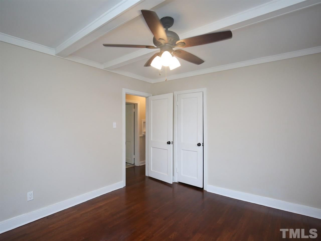 312 Colleton Road Raleigh, NC 27610 - Photo 8 of 25 an empty room with wooden floor fan and windows