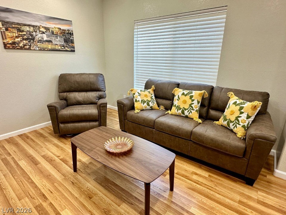 9580 West Reno Avenue, Unit 169 Las Vegas, NV 89148 - Photo 2 of 15 Well-lit living room space features rich flooring and a neutral color palette.