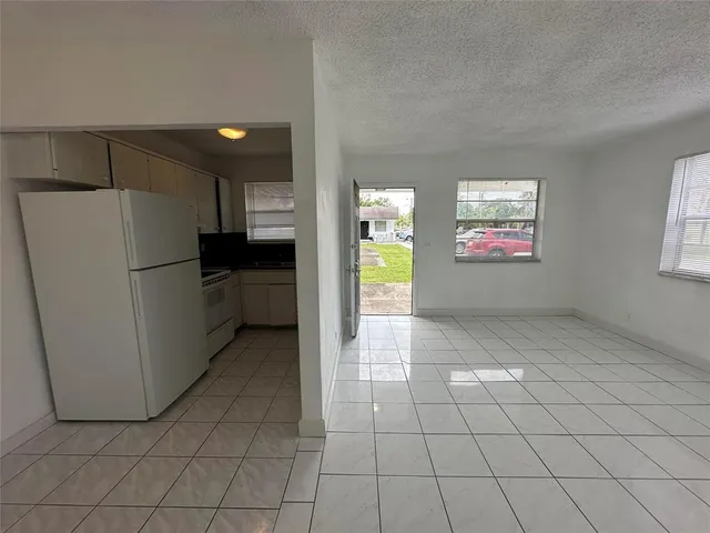 a view of a kitchen with refrigerator and window