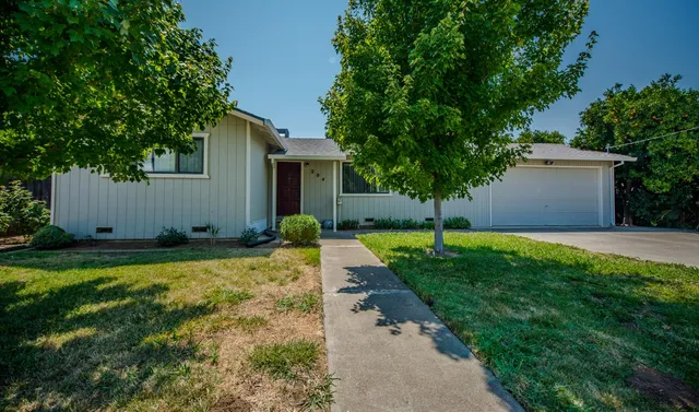 a view of a house with backyard and a tree