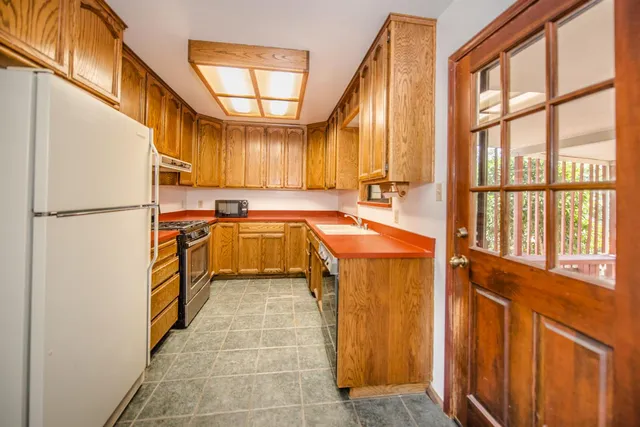 a kitchen with a refrigerator a sink and dishwasher next to a window