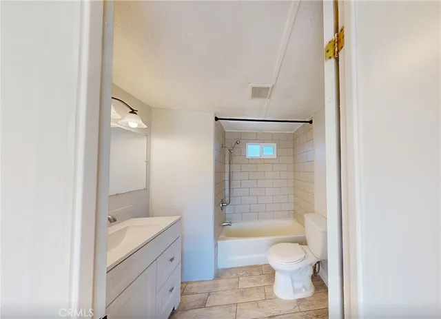 a bathroom with a granite countertop toilet a sink and a bathtub