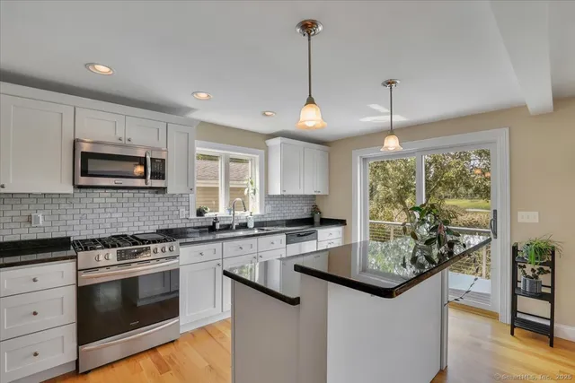 a kitchen with stainless steel appliances granite countertop a sink stove and microwave