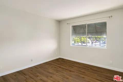 an empty room with wooden floor and a window
