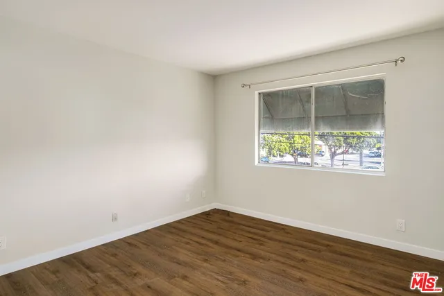 an empty room with wooden floor and a window
