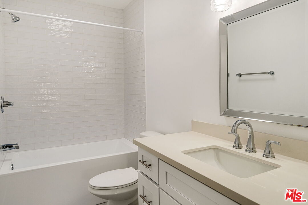 1342 Harvard Street, Unit 201 Santa Monica, CA 90404 - Photo 13 of 15 a bathroom with a granite countertop sink toilet and shower