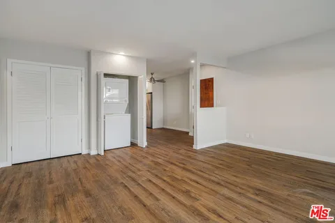 a view of empty room with wooden floor