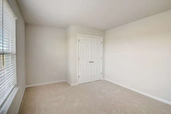 an empty room with windows and closet